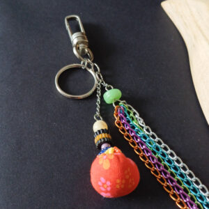 porte-clé et bijou de sac coloré composé de chaine bleu orange violet verte argenté et une perle faite main en tissu