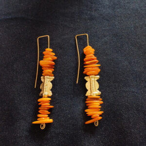 Pendantes d'oreilles en pierres chips jaunes, poids baoulé doré et acier doré à l'or fin. Structure rigide finie par un crochet d'oreille.